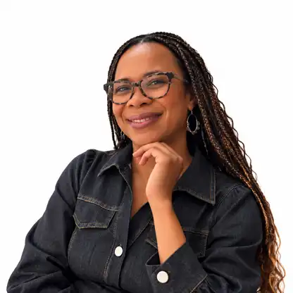 Simone Kirkpatrick, smiling, resting her chin on her hand, in a dark denim shirt